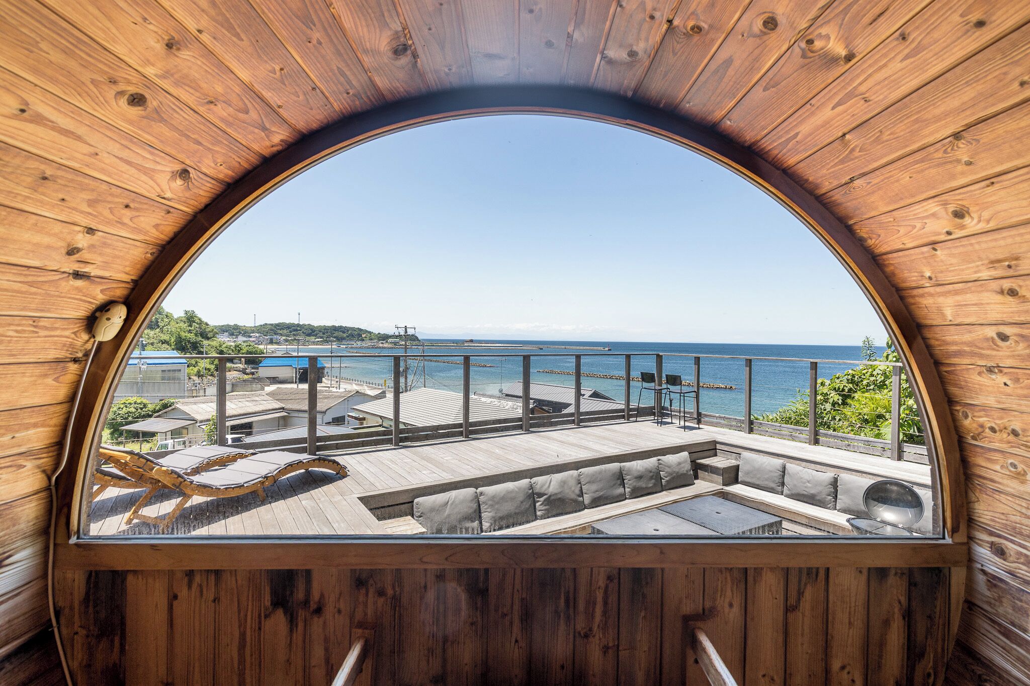 A wooden deck with seating and a view of the sea.
