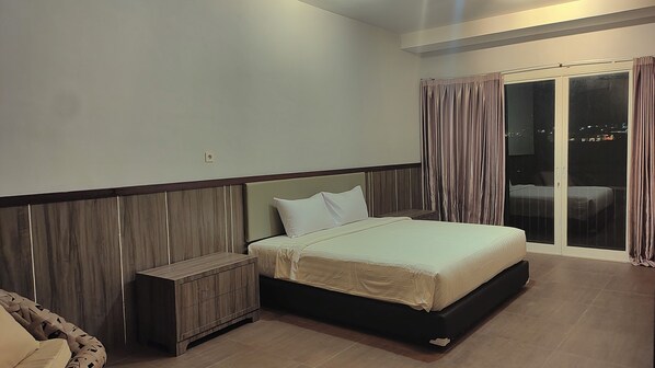 A bedroom with a bed, nightstand, and a view of the outside through a sliding door.