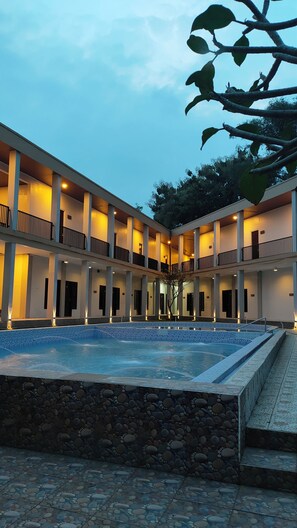 A hotel with a central courtyard, multiple balconies, and a swimming pool. - Bwalk Hotel Malang (Malang)