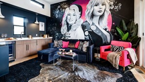 Un salon moderne avec un canapé, une table basse et une grande fresque murale.