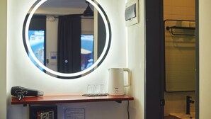 A hotel room with a round mirror, a coffee maker, and a safe. - Hotel Gray in Boracay (Boracay Island)