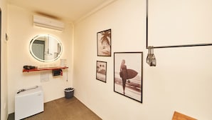 A hotel room with a compact layout, including a small kitchenette, a round mirror, and wall-mounted artwork. - Hotel Gray in Boracay (Boracay Island)