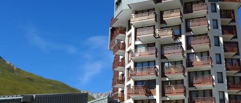 A multi-story hotel with balconies, a restaurant, and a ski rental sign.