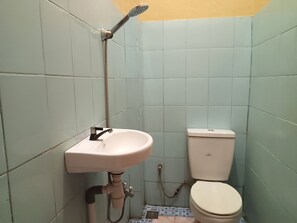 Uma casa de banho pequena com lavatório, sanita e chuveiro.