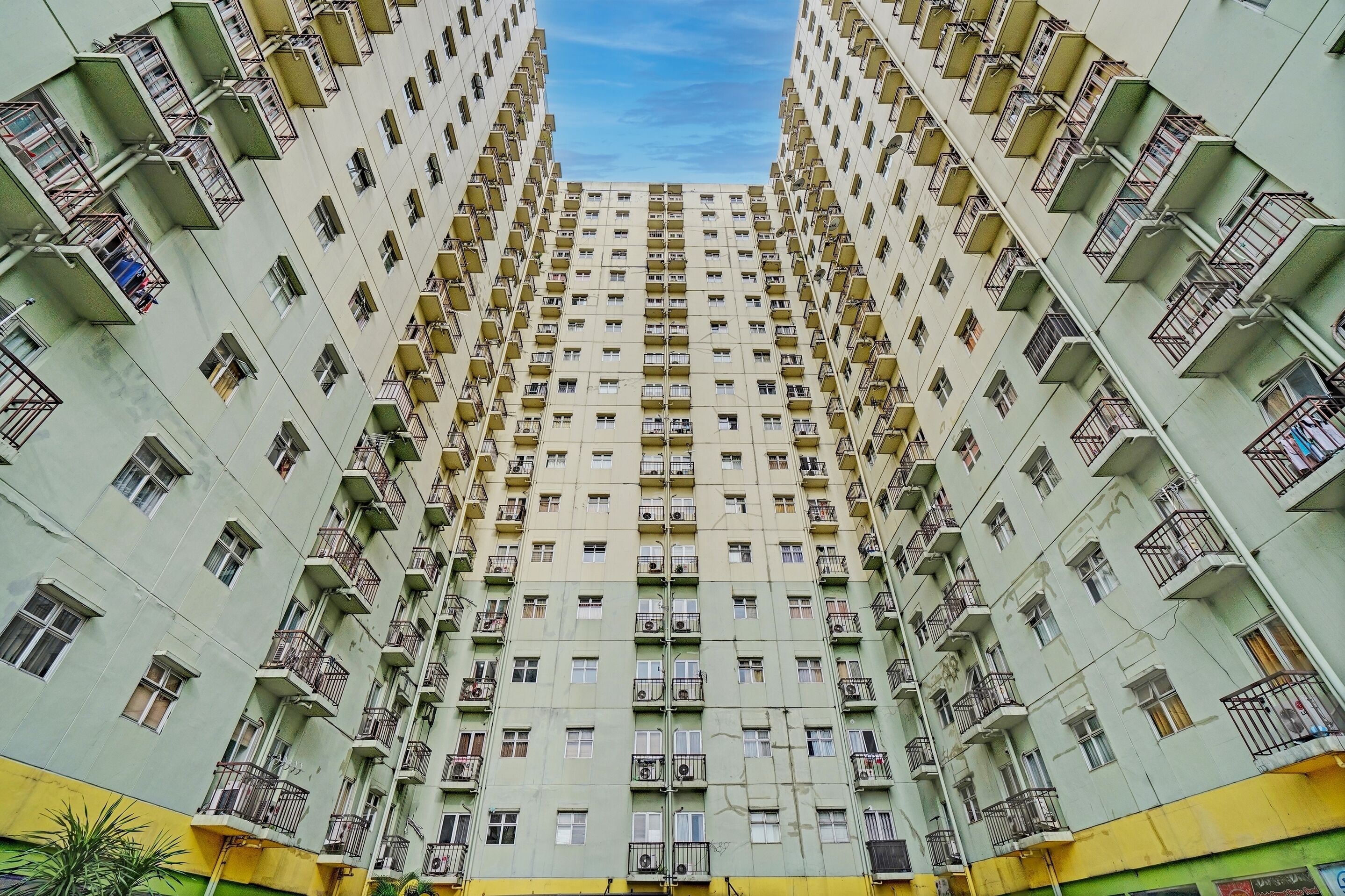 A high-rise residential building with multiple balconies, a central core, and a uniform facade.