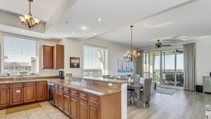 Una cocina amplia con una isla grande, armarios de madera y un comedor con vistas.