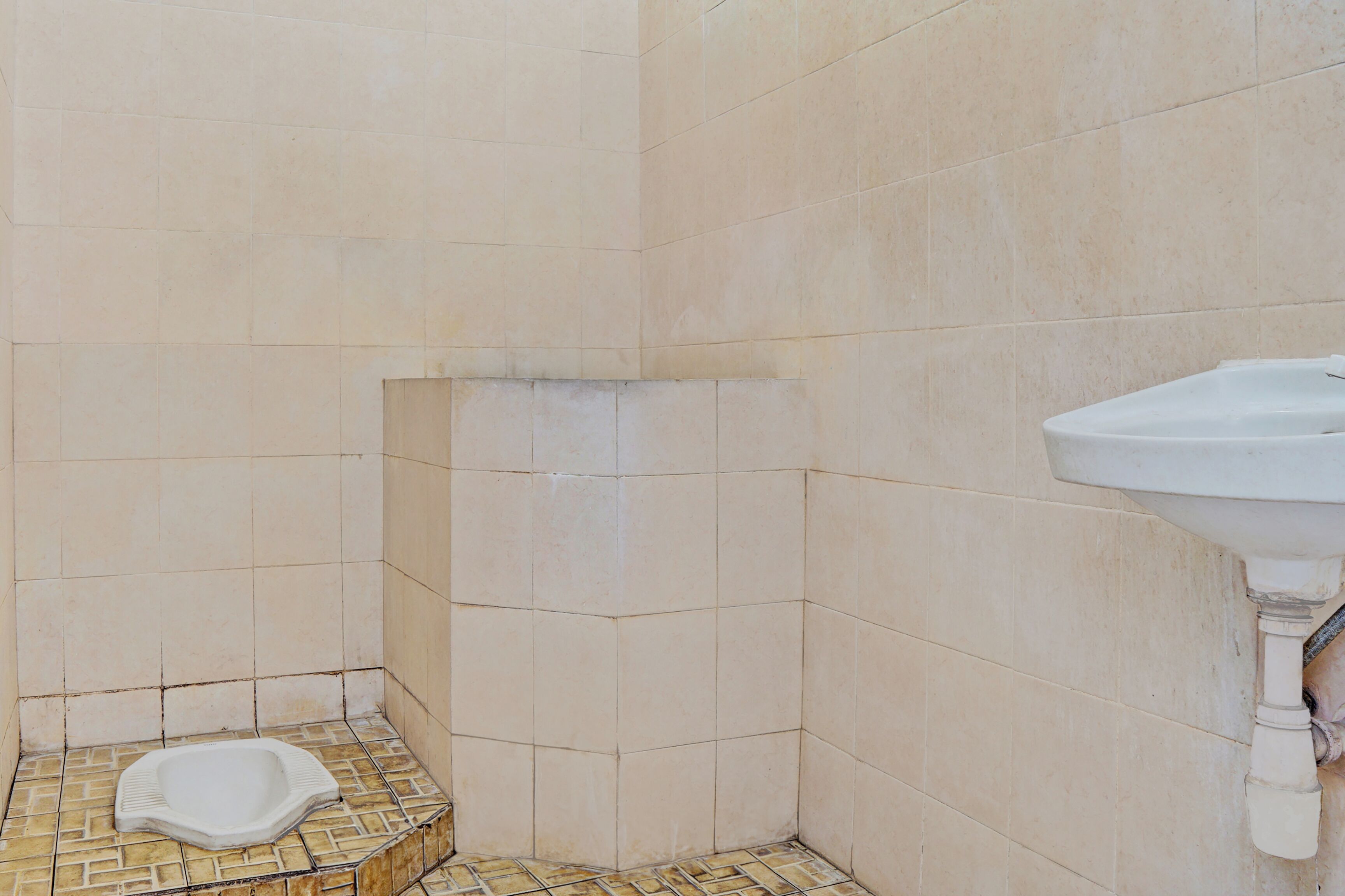 A small bathroom with a toilet, a sink, and tiled walls.