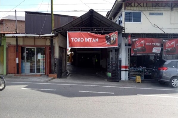 A storefront with a red banner advertising "TOKO INTAN" and a sign for "FULL TASTE" with a price tag. - Hotel O Home Stay Kembar Syariah (Binjai)
