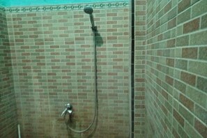 A shower with a handheld showerhead and a wall-mounted faucet. - Hotel O Home Stay Kembar Syariah (Binjai)