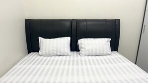 Un lit avec une couvre-lit à rayures et deux oreillers.