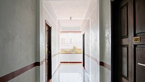 A corridor with a white floor, a barred window, and a door marked with the number 22C. - Hotel O Asri Homestay Syariah (Pekanbaru)