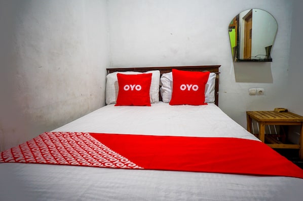Laptop workspace, bed sheets - OYO 93069 Penginapan Sumber Rizki (Sidoarjo)