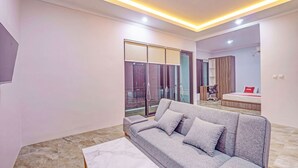 Ein modernes Wohnzimmer mit grauem Sofa, einem Marmor-Couchtisch und einer Glastür, die auf einen Balkon führt.