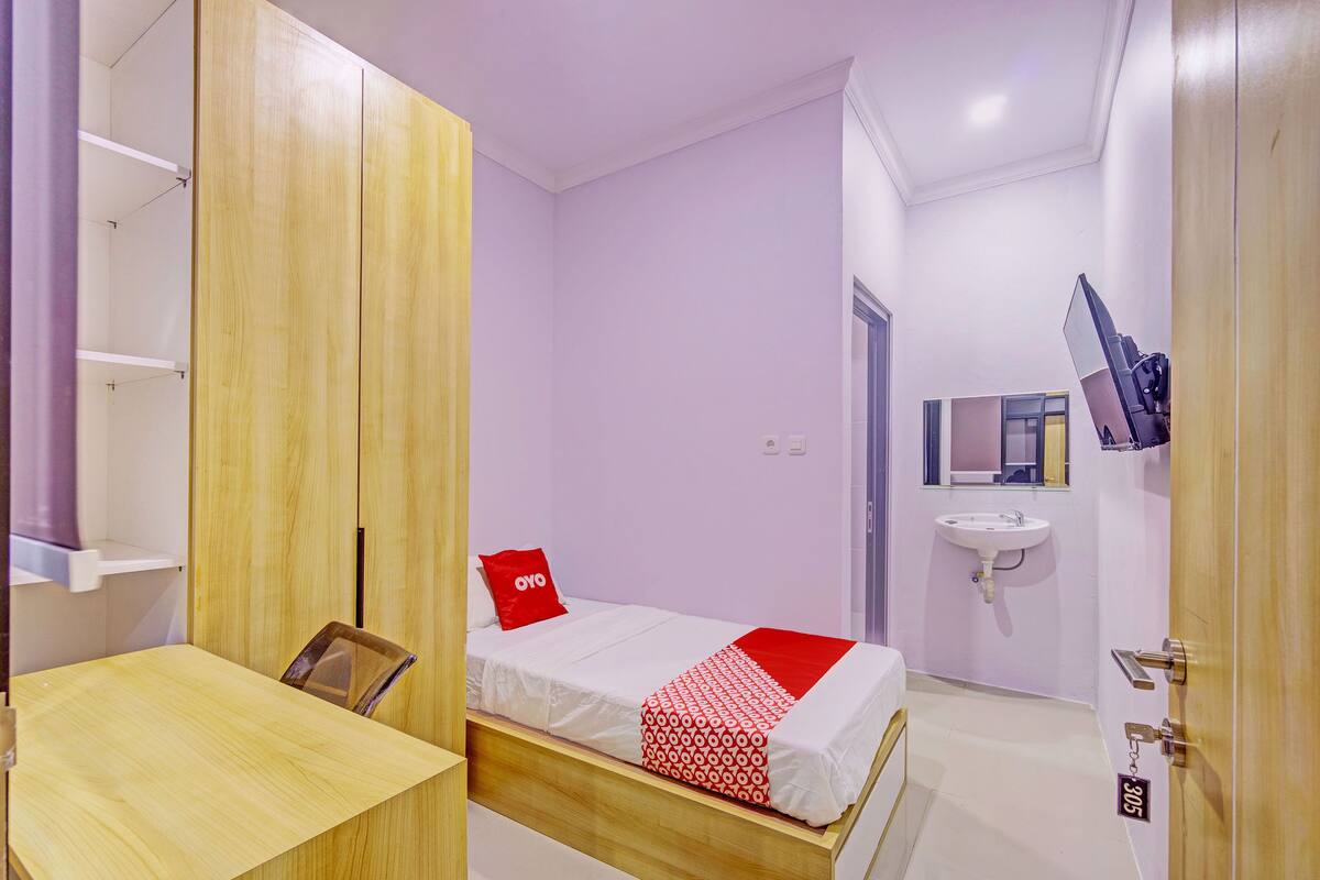 Ein Schlafzimmer mit Bett, Schreibtisch und Kleiderschrank.