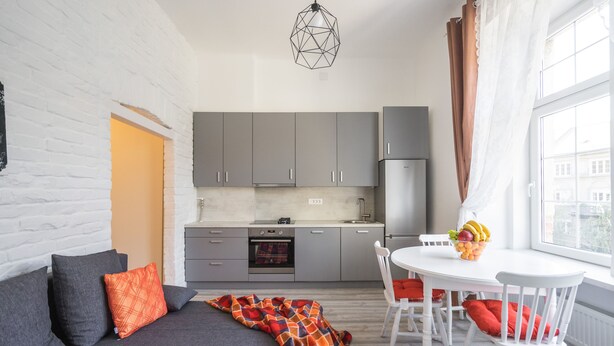 A modern kitchen with grey cabinets, a white countertop, and a built-in oven. - Park Ribnjak Apartment (Zagreb)