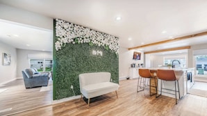A modern interior with a green wall, a sofa, and a dining area with bar stools. - Sleeps 20 * 4,400 Sq Ft * Indoor Heated Pool (Brillion)