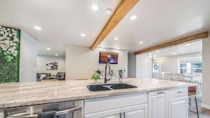 A modern kitchen with a granite countertop, stainless steel appliances, and a wooden ceiling beam. - Sleeps 20 * 4,400 Sq Ft * Indoor Heated Pool (Brillion)
