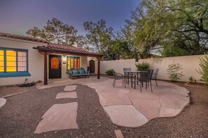 Un patio con pérgola, mobiliario exterior y una mesa con sillas.