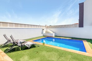 Relax by the rectangular pool surrounded by a deck and lounge chairs.