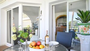 A dining table with a fruit bowl, wine glasses, and a bottle of wine. - Ideal apartment for golf lovers or families, with communal pool in Mijas Golf! (Mijas costa)