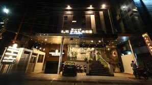 The exterior of Hotel I.P. Palace at night, featuring a modern facade, a staircase leading to the entrance, and a car parked in front. - Hotel I.P. Palace (Lucknow)