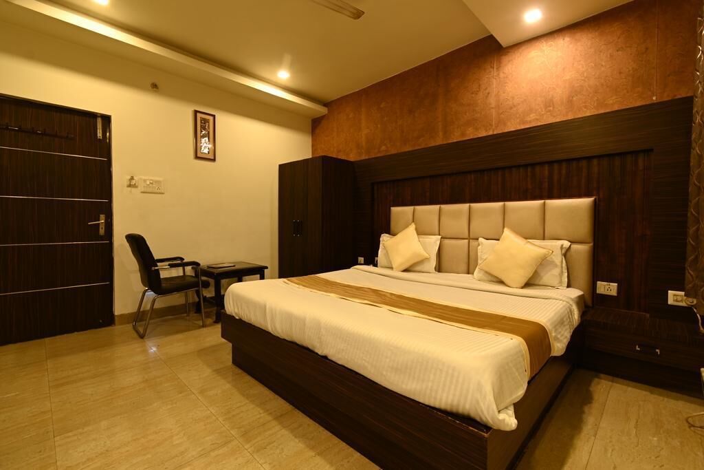 Una habitación de hotel con una cama grande, un escritorio y una silla.
