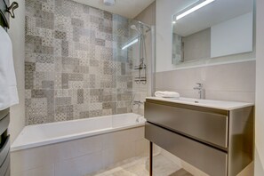 Chuveiro, secador de cabelo, toalhas de banho, papel higiênico