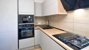 A modern kitchen with built-in appliances including a microwave, oven, and gas stove. - Vacation home Aurora by Interhome (Skradin)