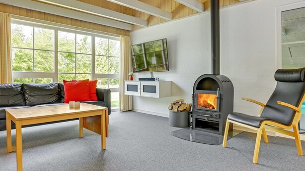A cozy living room with a fireplace, a sofa, a table, and a TV.