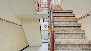 Una escalera con barandilla decorativa y escalones de cerámica, que lleva a un piso superior.