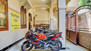 Una sala de exhibición de motocicletas con varias motos expuestas, suelo de baldosas y una puerta decorativa.
