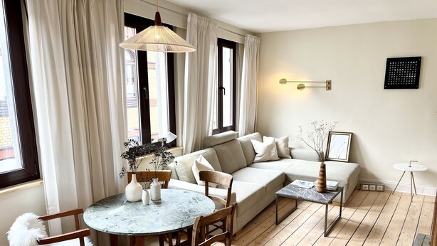 Un salon moderne avec un canapé, une table ronde et une table basse.