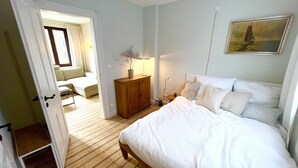 Une chambre à coucher avec un lit, une table de chevet, une lampe et un tableau au mur.