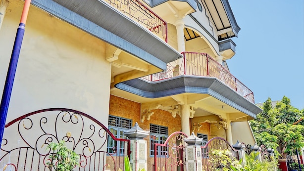 A multi-story building with balconies, a gated entrance, and a clear sky. - OYO 93108 Homestay H Syarif Syariah – RA Kartini (Gresik)