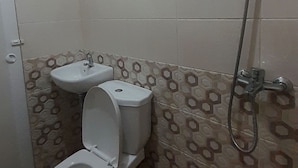 Une salle de bain équipée de toilettes, d’un bidet et d’une douche.
