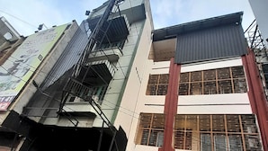 Un immeuble à plusieurs étages, doté d’un escalier imposant, de grandes fenêtres et d’une entrée de garage.
