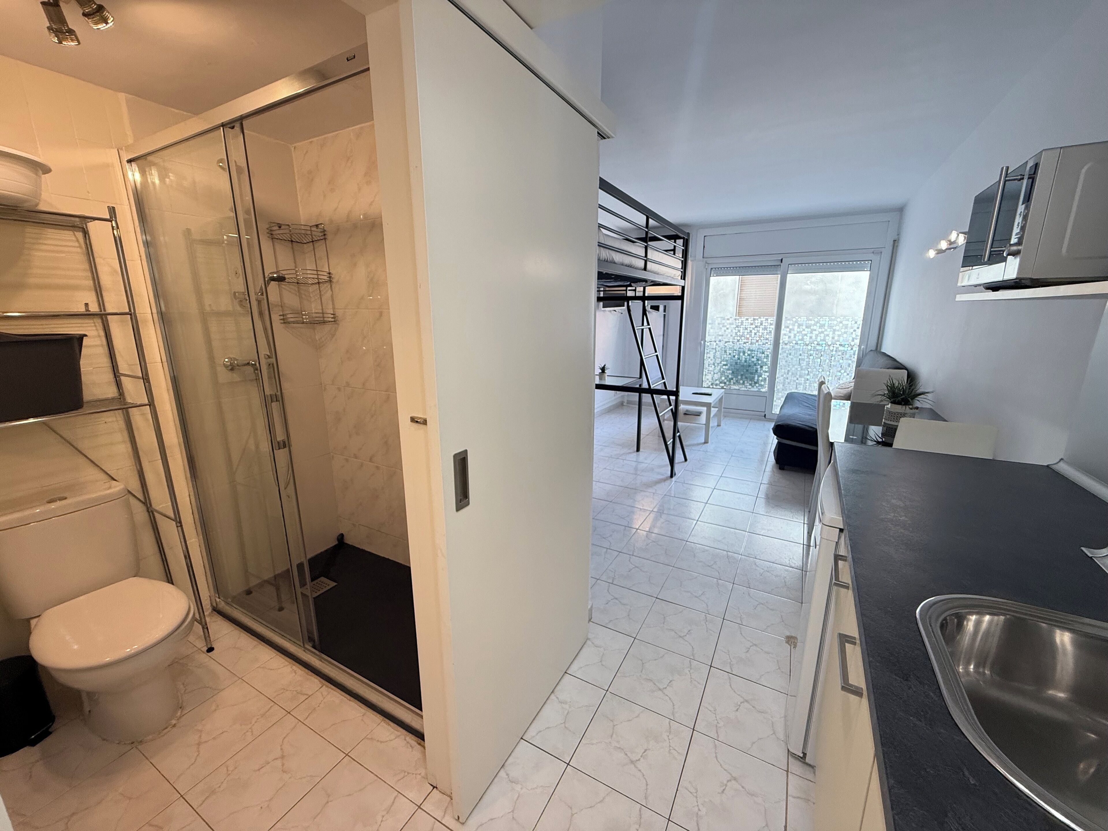 A modern bathroom with a glass shower enclosure, a toilet, and a sink.