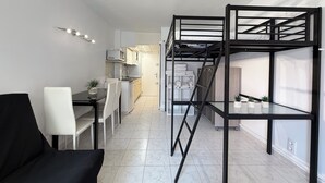 A compact living space with a kitchenette, a dining area, and a bunk bed. - Agi Estrella de Mar 2 Apartamento for rent in Roses Girona. (Roses)