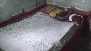 A small, dimly lit room with a single bed, a worn-out mattress, and a simple wooden frame. - Hotel O Barak Tambunan NearBelawan Port (Medan)