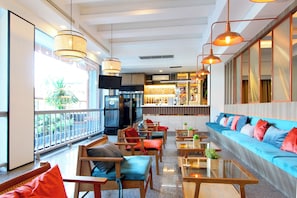 A hotel lobby with seating areas, a bar, and a television. - Coco Beach Hotel Jomtien Pattaya (Pattaya)