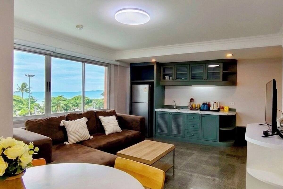Una sala moderna con sofá, mesa de centro y vista al océano.