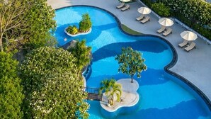Een hotel met meerdere verdiepingen, een zwembad en uitzicht op zee.