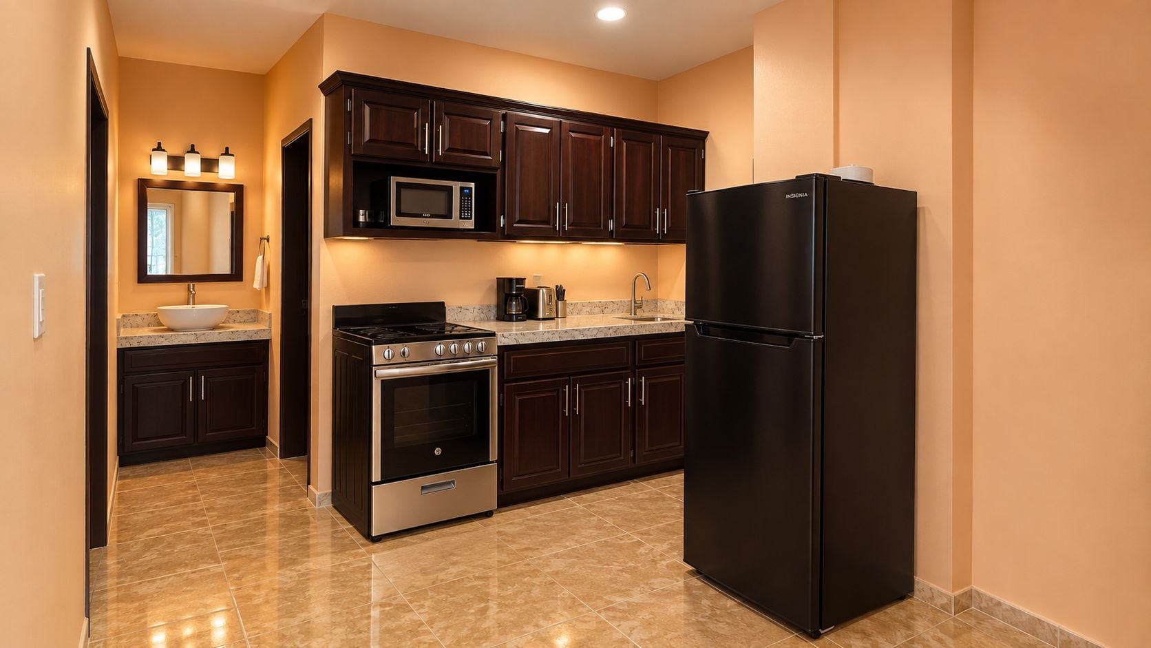 A kitchen with dark wood cabinets, a stainless steel oven, a black refrigerator, and a microwave.