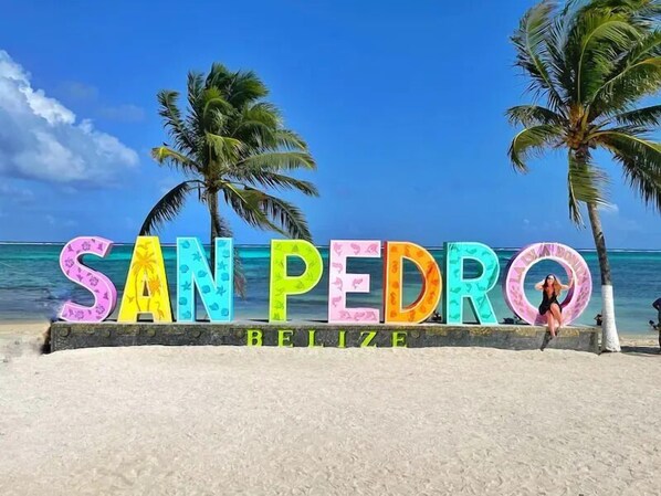 A beach sign with 'SAN PEDRO BELIZE' written in colorful letters. - Sea Horizon (San Pedro)