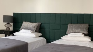 Una habitación de hotel con dos camas, una mesita de noche y una lámpara.