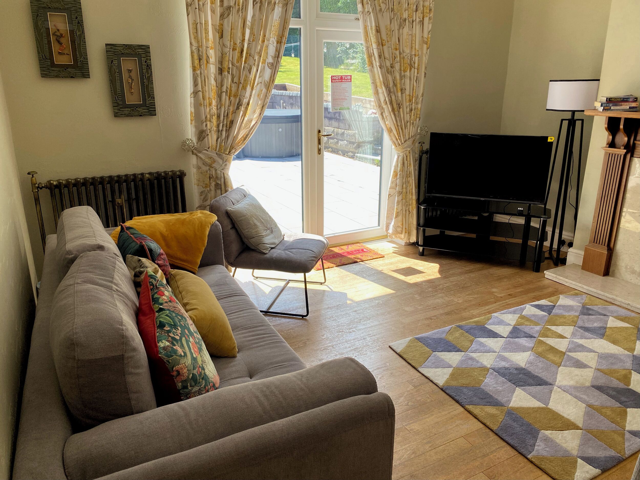 A living room with a sofa, a television, and a radiator.