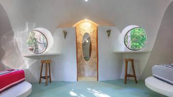 A room with a unique architectural design, featuring circular windows, a central archway, and a light-colored floor.