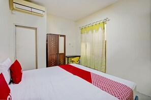 Relax in this inviting room with a comfortable bed, a stylish wardrobe, and a convenient table and chair.