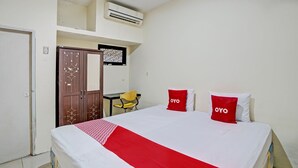 Une chambre d’hôtel équipée d’un lit, d’une armoire, d’un bureau et d’un appareil de climatisation.