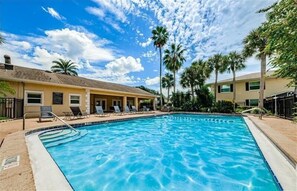Relax by the pool surrounded by lush greenery and lounge chairs.